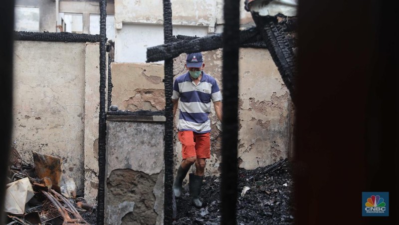 Warga membawa barang yang masih bisa diselamatkan di pemukiman yang terbakar di Jalan Bangka Buntu, Mampang Prapatan, Jakarta, Jumat (30/12/2022). (վ/Muhammad Sabki)