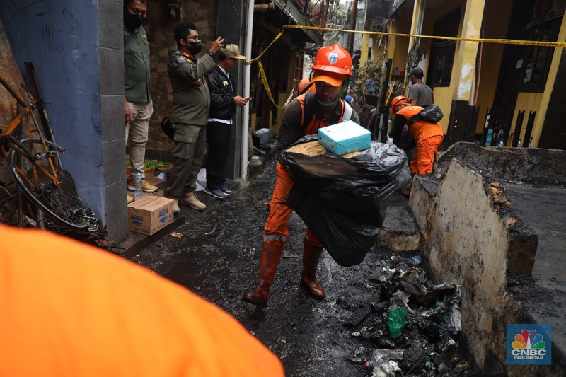 Warga membawa barang yang masih bisa diselamatkan di pemukiman yang terbakar di Jalan Bangka Buntu, Mampang Prapatan, Jakarta, Jumat (30/12/2022). (CNBC Indonesia/Muhammad Sabki)