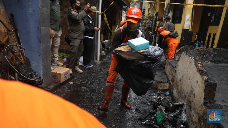 Warga membawa barang yang masih bisa diselamatkan di pemukiman yang terbakar di Jalan Bangka Buntu, Mampang Prapatan, Jakarta, Jumat (30/12/2022). (վ/Muhammad Sabki)
