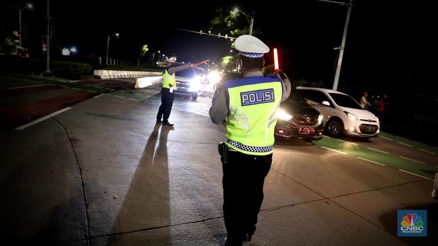 Petugas Polisi lalu lintas bersama dishub memasang pembatas lalu lintas saat penutupan jalan untuk car free night di Bundaran Senayan, Jakarta, Sabtu, 31/12. (CNBC Indonesia / Muhammad Sabki)