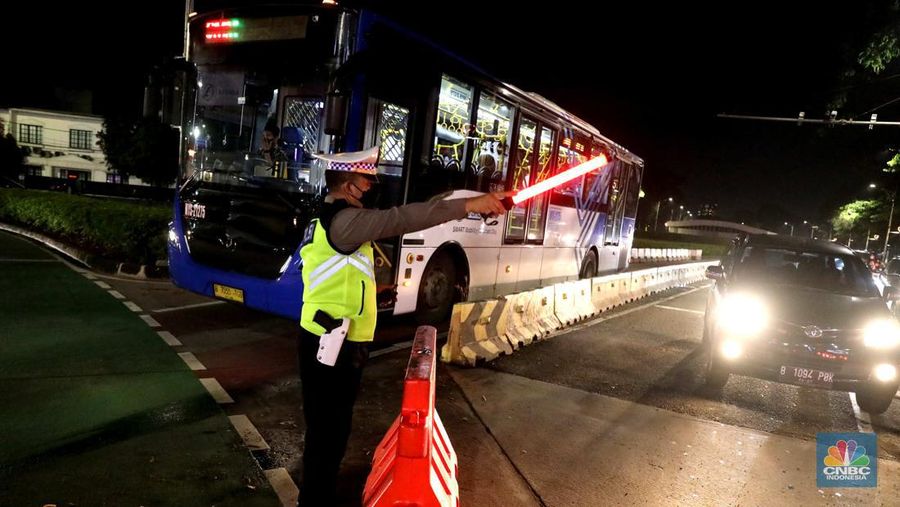 Petugas Polisi lalu lintas bersama dishub memasang pembatas lalu lintas saat penutupan jalan untuk car free night di Bundaran Senayan, Jakarta, Sabtu, 31/12. (CNBC Indonesia / Muhammad Sabki)