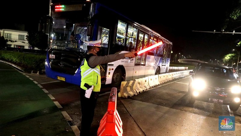Petugas Polisi lalu lintas bersama dishub memasang pembatas lalu lintas saat penutupan jalan untuk car free night di Bundaran Senayan, Jakarta, Sabtu, 31/12. (CNBC Indonesia / Muhammad Sabki)