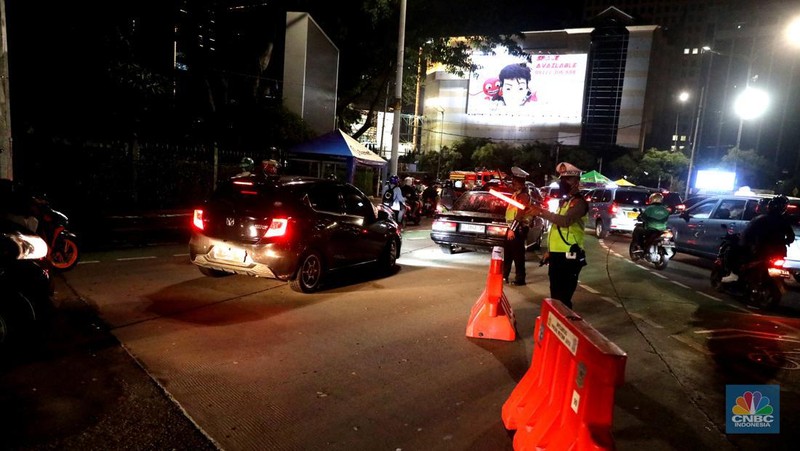 Petugas Polisi lalu lintas bersama dishub memasang pembatas lalu lintas saat penutupan jalan untuk car free night di Bundaran Senayan, Jakarta, Sabtu, 31/12. (CNBC Indonesia / Muhammad Sabki)