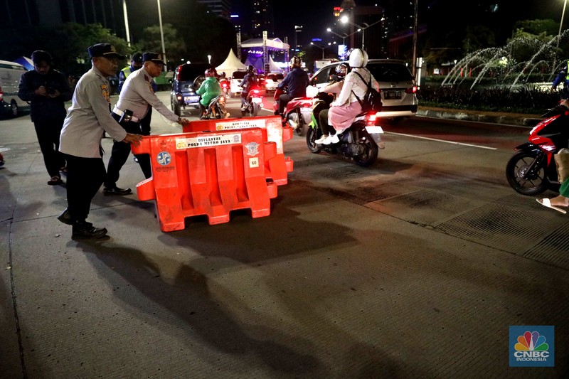 Petugas Polisi lalu lintas bersama dishub memasang pembatas lalu lintas saat penutupan jalan untuk car free night di Bundaran Senayan, Jakarta, Sabtu, 31/12. Petugas Polisi lalu lintas bersama dishub memasang pembatas lalu lintas saat penutupan jalan untuk car free night di Bundaran Senayan, Jakarta, Sabtu, 31/12. (CNBC Indonesia / Muhammad Sabki)