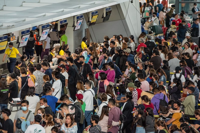 1245918972 Passengers wait for information about their flights at terminal 3 of Ninoy Aquino International Airport in Pasay, Metro Manila on January 1, 2023. - Thousands of travellers were stranded at Philippine airports on January 1 after a