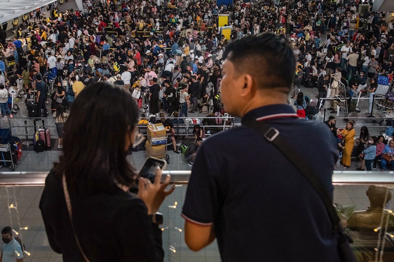 1245918972 Passengers wait for information about their flights at terminal 3 of Ninoy Aquino International Airport in Pasay, Metro Manila on January 1, 2023. - Thousands of travellers were stranded at Philippine airports on January 1 after a