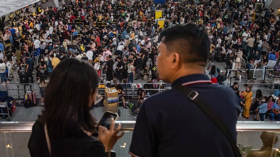 Passengers wait for information about their flights at terminal 3 of Ninoy Aquino International Airport in Pasay, Metro Manila on January 1, 2023. - Thousands of travellers were stranded at Philippine airports on January 1 after a 