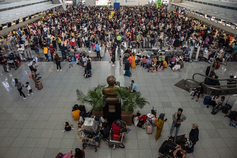 1245918972 Passengers wait for information about their flights at terminal 3 of Ninoy Aquino International Airport in Pasay, Metro Manila on January 1, 2023. - Thousands of travellers were stranded at Philippine airports on January 1 after a