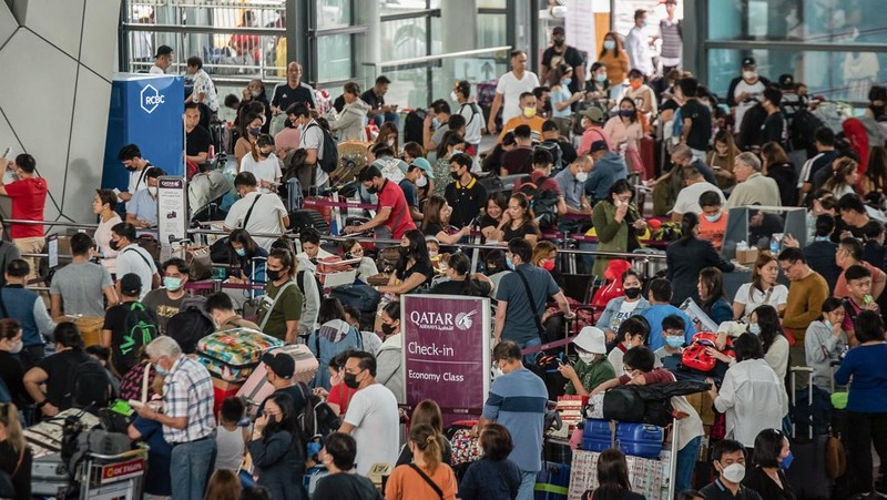 Passengers wait for information about their flights at terminal 3 of Ninoy Aquino International Airport in Pasay, Metro Manila on January 1, 2023. - Thousands of travellers were stranded at Philippine airports on January 1 after a 