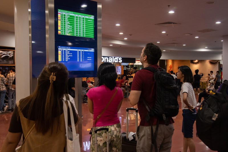 1245918972 Passengers wait for information about their flights at terminal 3 of Ninoy Aquino International Airport in Pasay, Metro Manila on January 1, 2023. - Thousands of travellers were stranded at Philippine airports on January 1 after a