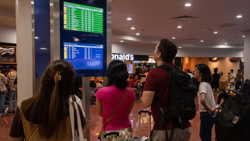 Passengers wait for information about their flights at terminal 3 of Ninoy Aquino International Airport in Pasay, Metro Manila on January 1, 2023. - Thousands of travellers were stranded at Philippine airports on January 1 after a 