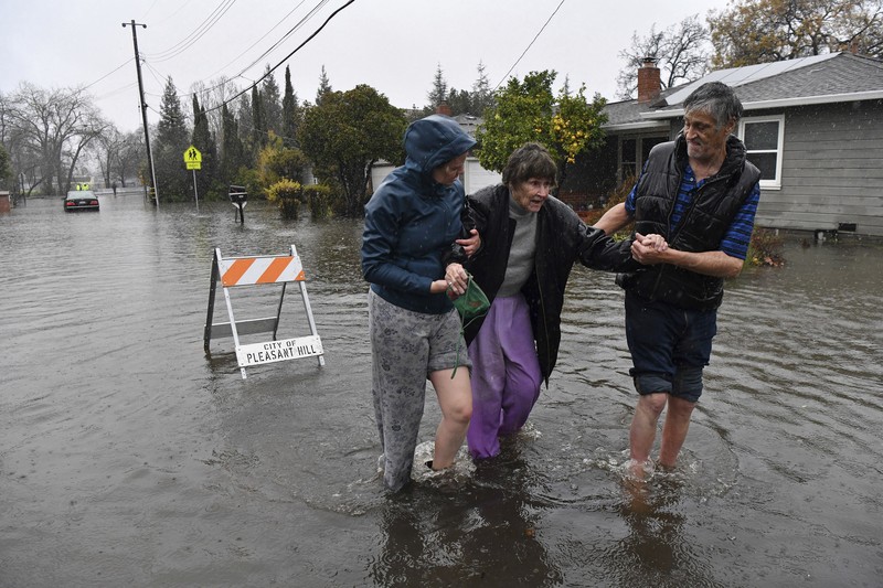 Three vehicles are submerged on Dillard Road west of Highway 99 in south Sacramento County in Wilton, Calif., Sunday, Jan. 1, 2023, after heavy rains on New Year's Eve produced levee breaks. Saturday's system was warmer and wetter, while storms this week will be colder, said Hannah Chandler-Cooley, a meteorologist at the National Weather Service in Sacramento. The Sacramento region could receive a total of 4 to 5 inches (10 to 13 centimeters) of rain over the week, Chandler-Cooley said. (Hector Amezcua/The Sacramento Bee via AP)