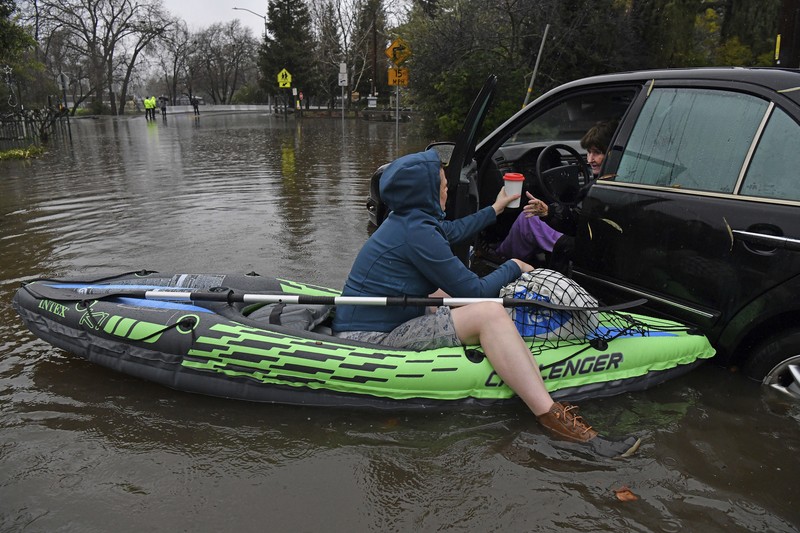Three vehicles are submerged on Dillard Road west of Highway 99 in south Sacramento County in Wilton, Calif., Sunday, Jan. 1, 2023, after heavy rains on New Year's Eve produced levee breaks. Saturday's system was warmer and wetter, while storms this week will be colder, said Hannah Chandler-Cooley, a meteorologist at the National Weather Service in Sacramento. The Sacramento region could receive a total of 4 to 5 inches (10 to 13 centimeters) of rain over the week, Chandler-Cooley said. (Hector Amezcua/The Sacramento Bee via AP)