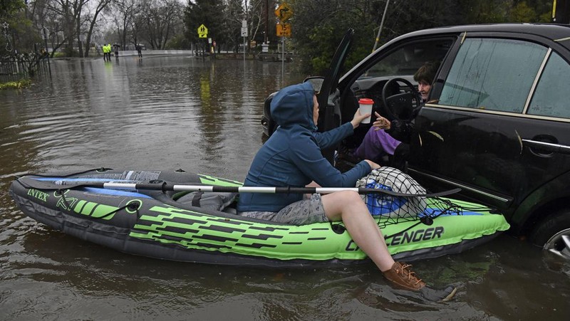 Three vehicles are submerged on Dillard Road west of Highway 99 in south Sacramento County in Wilton, Calif., Sunday, Jan. 1, 2023, after heavy rains on New Year's Eve produced levee breaks. Saturday's system was warmer and wetter, while storms this week will be colder, said Hannah Chandler-Cooley, a meteorologist at the National Weather Service in Sacramento. The Sacramento region could receive a total of 4 to 5 inches (10 to 13 centimeters) of rain over the week, Chandler-Cooley said. (Hector Amezcua/The Sacramento Bee via AP)