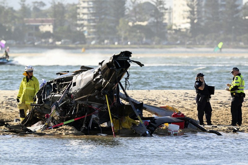 Dua helikopter bertabrakan menewaskan beberapa penumpang dan melukai beberapa lainnya dalam kecelakaan yang menarik bantuan darurat dari pengunjung pantai yang menikmati air selama musim panas selatan. Pekerja darurat memeriksa helikopter di lokasi tabrakan dekat Seaworld, di Gold Coast, Australia, Senin, 2 Januari 2023. Dua helikopter bertabrakan menewaskan beberapa penumpang dan melukai beberapa lainnya dalam kecelakaan yang menarik bantuan darurat dari pengunjung pantai yang menikmati air selama musim panas selatan. (Dave Hunt/AAP Image via AP)