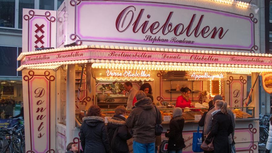 An outdoor stand in central Amsterdam selling oliebollen, a snack similar to a donut, but without a hole in the center. Oliebollen are a traditional New Year's food.