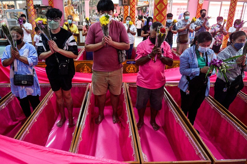 Umat berbaring dan berdoa di dalam peti mati untuk menghilangkan nasib buruk dan terlahir kembali untuk awal yang baru di Tahun Baru di sebuah kuil di Nonthaburi, di pinggiran Bangkok, Thailand 2 Januari 2023. (REUTERS/Chalinee Thirasupa)