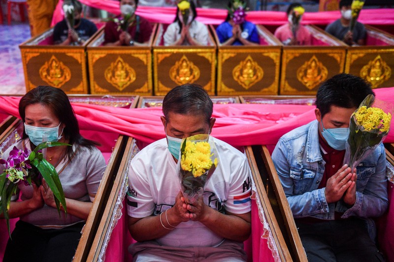 Umat berbaring dan berdoa di dalam peti mati untuk menghilangkan nasib buruk dan terlahir kembali untuk awal yang baru di Tahun Baru di sebuah kuil di Nonthaburi, di pinggiran Bangkok, Thailand 2 Januari 2023. Umat berbaring dan berdoa di dalam peti mati untuk menghilangkan nasib buruk dan terlahir kembali untuk awal yang baru di Tahun Baru di sebuah kuil di Nonthaburi, di pinggiran Bangkok, Thailand 2 Januari 2023. (REUTERS/Chalinee Thirasupa)