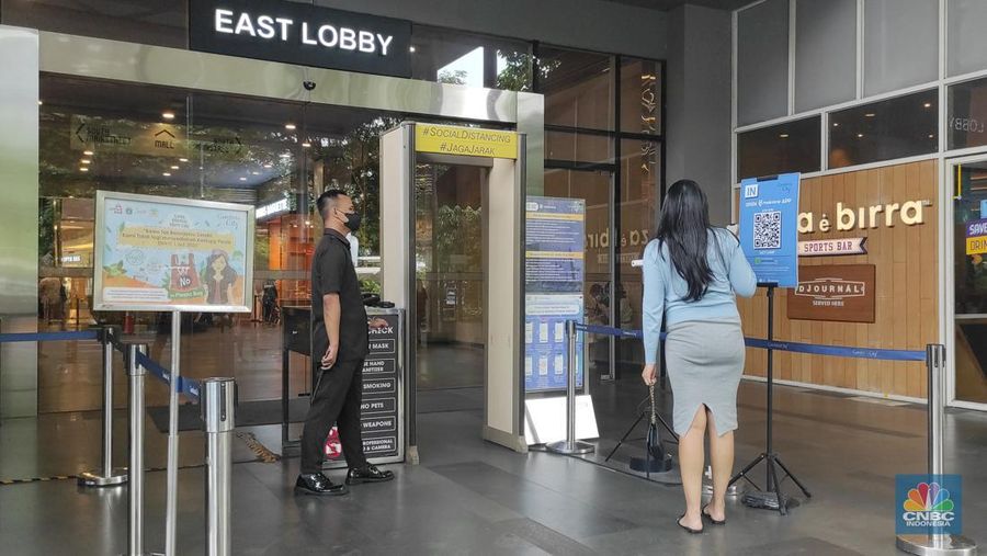 Pengunjung memindai kode batang (scan barcode) aplikasi peduli lindungi saat memasuki Gandaria City, Jakarta, Senin (2/1/2023). Presiden Joko Widodo (Jokowi) resmi mencabut Pemberlakuan Pembatasan Kegiatan Masyarakat (PPKM) pada Jumat (30/12/2022). (CNBC Indonesia/Andrean Kristianto)
