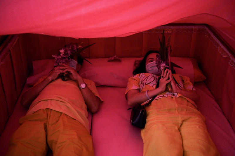 Umat berbaring dan berdoa di dalam peti mati untuk menghilangkan nasib buruk dan terlahir kembali untuk awal yang baru di Tahun Baru di sebuah kuil di Nonthaburi, di pinggiran Bangkok, Thailand 2 Januari 2023. (REUTERS/Chalinee Thirasupa)