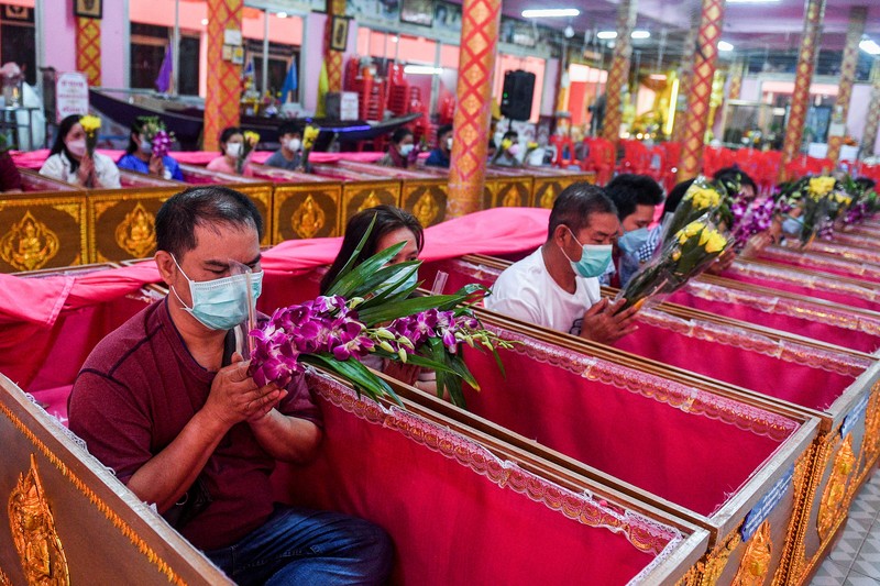Umat berbaring dan berdoa di dalam peti mati untuk menghilangkan nasib buruk dan terlahir kembali untuk awal yang baru di Tahun Baru di sebuah kuil di Nonthaburi, di pinggiran Bangkok, Thailand 2 Januari 2023. (REUTERS/Chalinee Thirasupa)