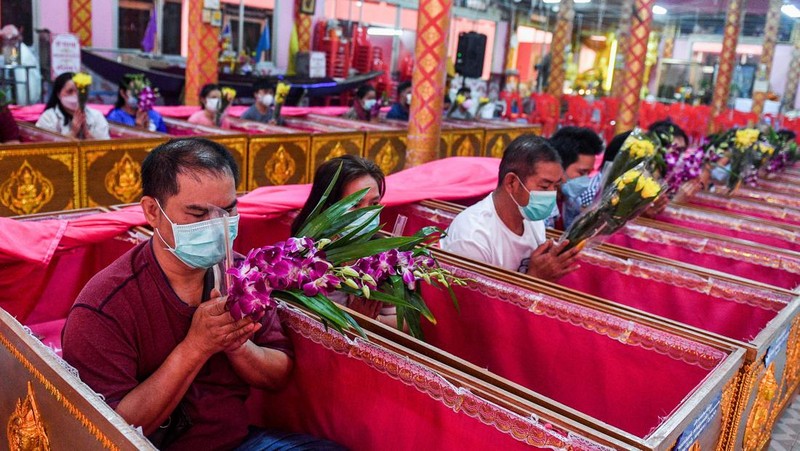 Umat berbaring dan berdoa di dalam peti mati untuk menghilangkan nasib buruk dan terlahir kembali untuk awal yang baru di Tahun Baru di sebuah kuil di Nonthaburi, di pinggiran Bangkok, Thailand 2 Januari 2023. (REUTERS/Chalinee Thirasupa)