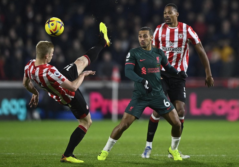 Rico Henry dari Brentford memperebutkan bola dengan Trent Alexander-Arnold dari Liverpool dalam laga Liga Inggris Brentford melawan Liverpool di Gtech Community Stadium, Selasa (2/1/2023). Brentford sukses mengalahkan Liverpool dengan skor 3-1. (Photo by Marc Atkins/Getty Images)