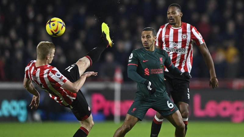Rico Henry dari Brentford memperebutkan bola dengan Trent Alexander-Arnold dari Liverpool dalam laga Liga Inggris Brentford melawan Liverpool di Gtech Community Stadium, Selasa (2/1/2023). Brentford sukses mengalahkan Liverpool dengan skor 3-1. (Photo by Marc Atkins/Getty Images)