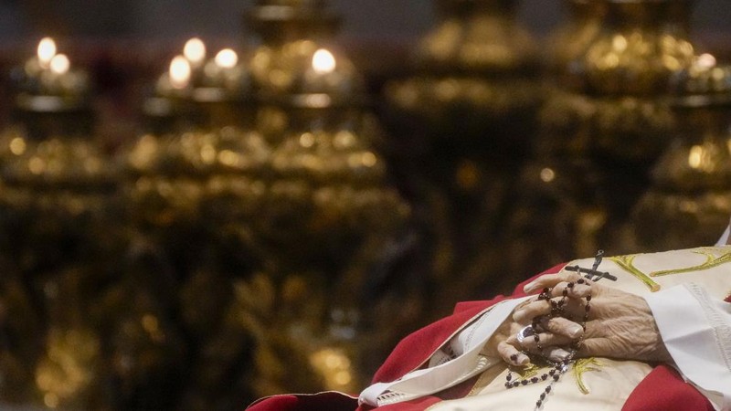 Orang-orang mengantre untuk memasuki Basilika Santo Petrus tempat mendiang Paus Benediktus XVI disemayamkan di Vatikan, Senin (2/1/2023). Ribuan orang memberi penghormatan terakhir untuk Paus Benediktus, teolog Jerman yang akan dikenang sebagai paus pertama dalam 600 tahun yang mengundurkan diri sejak Gregory XII tahun 1415 silam. Ia meninggal pada Sabtu (31/12) waktu setempat dalami usia 95 tahun dan pemakamannya akan diadakan Kamis, 5 Januari 2023. (AP Photo/Antonio Calanni)