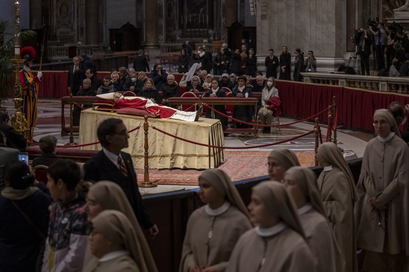 Persemayaman Paus Emeritus Benediktus XVI di dalam Basilika Santo Petrus di Vatikan Orang-orang mengantre untuk memasuki Basilika Santo Petrus tempat mendiang Paus Benediktus XVI disemayamkan di Vatikan, Senin (2/1/2023). Ribuan orang memberi penghormatan terakhir untuk Paus Benediktus, teolog Jerman yang akan dikenang sebagai paus pertama dalam 600 tahun yang mengundurkan diri sejak Gregory XII tahun 1415 silam. Ia meninggal pada Sabtu (31/12) waktu setempat dalami usia 95 tahun dan pemakamannya akan diadakan Kamis, 5 Januari 2023. (AP Photo/Antonio Calanni)