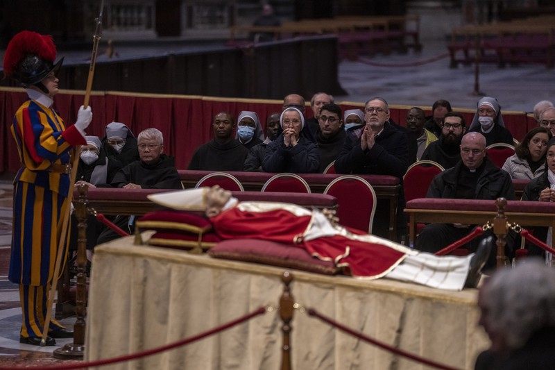 Persemayaman Paus Emeritus Benediktus XVI di dalam Basilika Santo Petrus di Vatikan Orang-orang mengantre untuk memasuki Basilika Santo Petrus tempat mendiang Paus Benediktus XVI disemayamkan di Vatikan, Senin (2/1/2023). Ribuan orang memberi penghormatan terakhir untuk Paus Benediktus, teolog Jerman yang akan dikenang sebagai paus pertama dalam 600 tahun yang mengundurkan diri sejak Gregory XII tahun 1415 silam. Ia meninggal pada Sabtu (31/12) waktu setempat dalami usia 95 tahun dan pemakamannya akan diadakan Kamis, 5 Januari 2023. (AP Photo/Antonio Calanni)