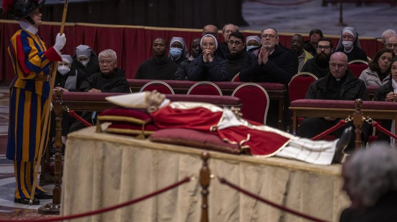 Orang-orang mengantre untuk memasuki Basilika Santo Petrus tempat mendiang Paus Benediktus XVI disemayamkan di Vatikan, Senin (2/1/2023). Ribuan orang memberi penghormatan terakhir untuk Paus Benediktus, teolog Jerman yang akan dikenang sebagai paus pertama dalam 600 tahun yang mengundurkan diri sejak Gregory XII tahun 1415 silam. Ia meninggal pada Sabtu (31/12) waktu setempat dalami usia 95 tahun dan pemakamannya akan diadakan Kamis, 5 Januari 2023. (AP Photo/Antonio Calanni)