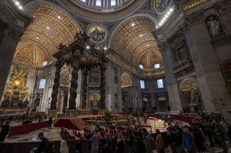Persemayaman Paus Emeritus Benediktus XVI di dalam Basilika Santo Petrus di Vatikan Orang-orang mengantre untuk memasuki Basilika Santo Petrus tempat mendiang Paus Benediktus XVI disemayamkan di Vatikan, Senin (2/1/2023). Ribuan orang memberi penghormatan terakhir untuk Paus Benediktus, teolog Jerman yang akan dikenang sebagai paus pertama dalam 600 tahun yang mengundurkan diri sejak Gregory XII tahun 1415 silam. Ia meninggal pada Sabtu (31/12) waktu setempat dalami usia 95 tahun dan pemakamannya akan diadakan Kamis, 5 Januari 2023. (AP Photo/Antonio Calanni)