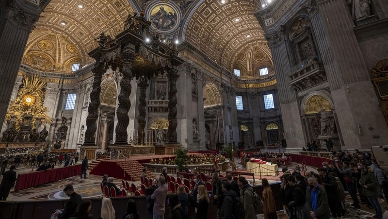 Orang-orang mengantre untuk memasuki Basilika Santo Petrus tempat mendiang Paus Benediktus XVI disemayamkan di Vatikan, Senin (2/1/2023). Ribuan orang memberi penghormatan terakhir untuk Paus Benediktus, teolog Jerman yang akan dikenang sebagai paus pertama dalam 600 tahun yang mengundurkan diri sejak Gregory XII tahun 1415 silam. Ia meninggal pada Sabtu (31/12) waktu setempat dalami usia 95 tahun dan pemakamannya akan diadakan Kamis, 5 Januari 2023. (AP Photo/Antonio Calanni)