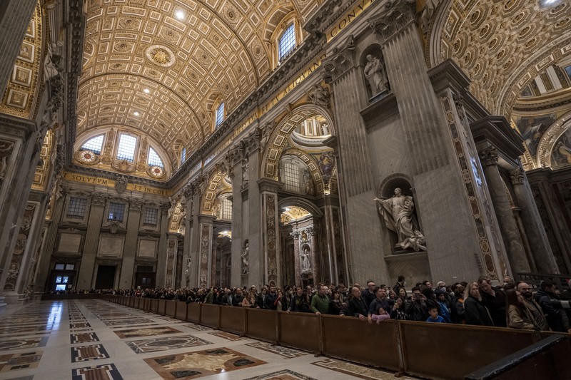 Persemayaman Paus Emeritus Benediktus XVI di dalam Basilika Santo Petrus di Vatikan Orang-orang mengantre untuk memasuki Basilika Santo Petrus tempat mendiang Paus Benediktus XVI disemayamkan di Vatikan, Senin (2/1/2023). Ribuan orang memberi penghormatan terakhir untuk Paus Benediktus, teolog Jerman yang akan dikenang sebagai paus pertama dalam 600 tahun yang mengundurkan diri sejak Gregory XII tahun 1415 silam. Ia meninggal pada Sabtu (31/12) waktu setempat dalami usia 95 tahun dan pemakamannya akan diadakan Kamis, 5 Januari 2023. (AP Photo/Antonio Calanni)