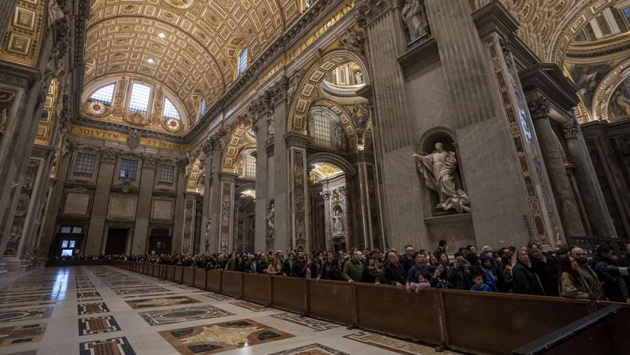 Orang-orang mengantre untuk memasuki Basilika Santo Petrus tempat mendiang Paus Benediktus XVI disemayamkan di Vatikan, Senin (2/1/2023). Ribuan orang memberi penghormatan terakhir untuk Paus Benediktus, teolog Jerman yang akan dikenang sebagai paus pertama dalam 600 tahun yang mengundurkan diri sejak Gregory XII tahun 1415 silam. Ia meninggal pada Sabtu (31/12) waktu setempat dalami usia 95 tahun dan pemakamannya akan diadakan Kamis, 5 Januari 2023. (AP Photo/Antonio Calanni)