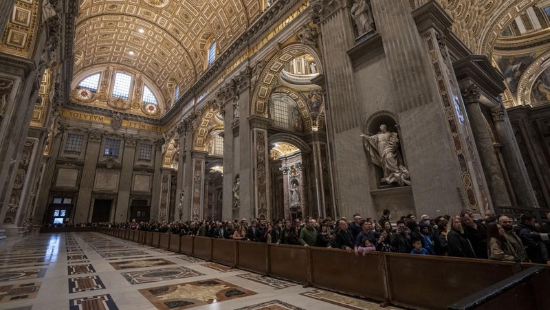 Orang-orang mengantre untuk memasuki Basilika Santo Petrus tempat mendiang Paus Benediktus XVI disemayamkan di Vatikan, Senin (2/1/2023). Ribuan orang memberi penghormatan terakhir untuk Paus Benediktus, teolog Jerman yang akan dikenang sebagai paus pertama dalam 600 tahun yang mengundurkan diri sejak Gregory XII tahun 1415 silam. Ia meninggal pada Sabtu (31/12) waktu setempat dalami usia 95 tahun dan pemakamannya akan diadakan Kamis, 5 Januari 2023. (AP Photo/Antonio Calanni)
