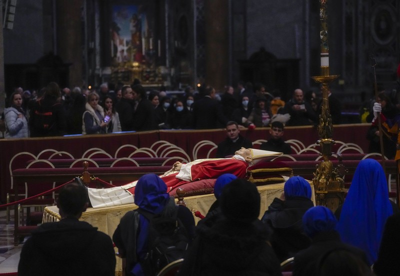 Orang-orang mengantre untuk memasuki Basilika Santo Petrus tempat mendiang Paus Benediktus XVI disemayamkan di Vatikan, Senin (2/1/2023). Ribuan orang memberi penghormatan terakhir untuk Paus Benediktus, teolog Jerman yang akan dikenang sebagai paus pertama dalam 600 tahun yang mengundurkan diri sejak Gregory XII tahun 1415 silam. Ia meninggal pada Sabtu (31/12) waktu setempat dalami usia 95 tahun dan pemakamannya akan diadakan Kamis, 5 Januari 2023. (AP Photo/Antonio Calanni)