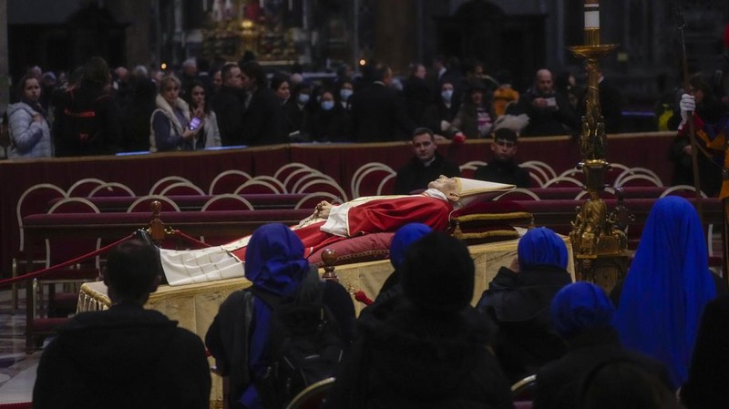 Orang-orang mengantre untuk memasuki Basilika Santo Petrus tempat mendiang Paus Benediktus XVI disemayamkan di Vatikan, Senin (2/1/2023). Ribuan orang memberi penghormatan terakhir untuk Paus Benediktus, teolog Jerman yang akan dikenang sebagai paus pertama dalam 600 tahun yang mengundurkan diri sejak Gregory XII tahun 1415 silam. Ia meninggal pada Sabtu (31/12) waktu setempat dalami usia 95 tahun dan pemakamannya akan diadakan Kamis, 5 Januari 2023. (AP Photo/Antonio Calanni)