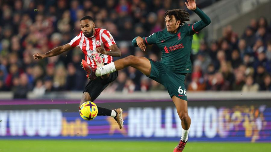 Rico Henry dari Brentford memperebutkan bola dengan Trent Alexander-Arnold dari Liverpool dalam laga Liga Inggris Brentford melawan Liverpool di Gtech Community Stadium, Selasa (2/1/2023). Brentford sukses mengalahkan Liverpool dengan skor 3-1. (Photo by Marc Atkins/Getty Images)