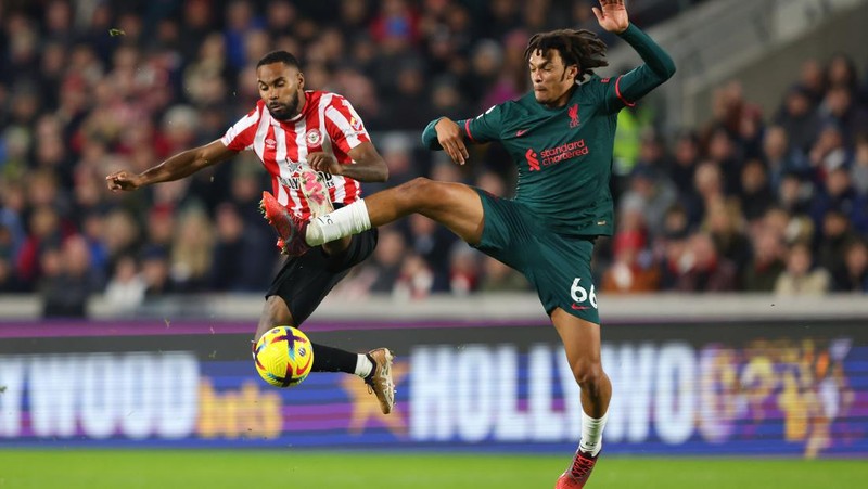 Rico Henry dari Brentford memperebutkan bola dengan Trent Alexander-Arnold dari Liverpool dalam laga Liga Inggris Brentford melawan Liverpool di Gtech Community Stadium, Selasa (2/1/2023). Brentford sukses mengalahkan Liverpool dengan skor 3-1. (Photo by Marc Atkins/Getty Images)
