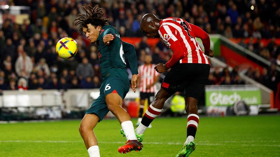 Rico Henry dari Brentford memperebutkan bola dengan Trent Alexander-Arnold dari Liverpool dalam laga Liga Inggris Brentford melawan Liverpool di Gtech Community Stadium, Selasa (2/1/2023). Brentford sukses mengalahkan Liverpool dengan skor 3-1. (Photo by Marc Atkins/Getty Images)