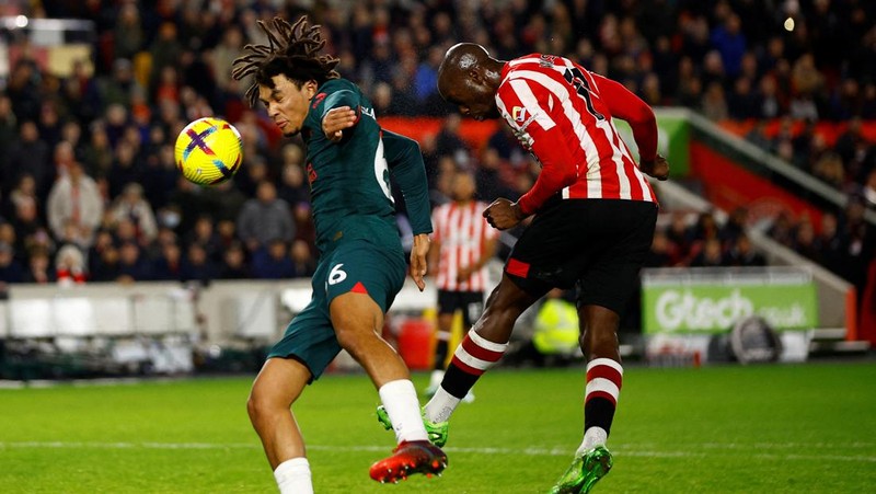Rico Henry dari Brentford memperebutkan bola dengan Trent Alexander-Arnold dari Liverpool dalam laga Liga Inggris Brentford melawan Liverpool di Gtech Community Stadium, Selasa (2/1/2023). Brentford sukses mengalahkan Liverpool dengan skor 3-1. (Photo by Marc Atkins/Getty Images)