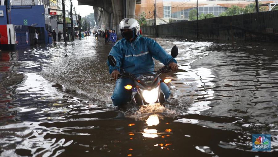 Warga menerobos banjir menggunakan sepeda motor di kawasan Seskol, Jakarta, Rabu (4/1/2023). Hujan deras mengguyur sejumlah wilayah di DKI Jakarta. (վ/Tri Susilo)