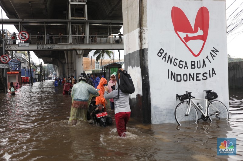 Warga menerobos banjir menggunakan sepeda motor di kawasan Seskol, Jakarta, Rabu (4/1/2023). Hujan deras mengguyur sejumlah wilayah di DKI Jakarta. (CNBC Indonesia/Tri Susilo)
