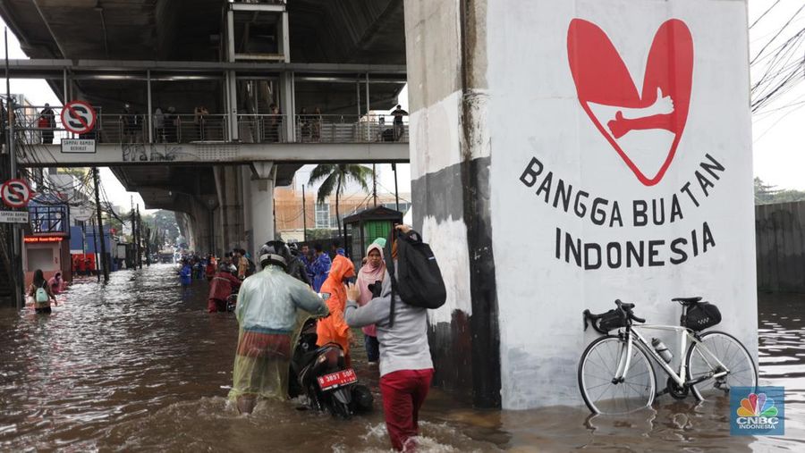 Warga menerobos banjir menggunakan sepeda motor di kawasan Seskol, Jakarta, Rabu (4/1/2023). Hujan deras mengguyur sejumlah wilayah di DKI Jakarta. (վ/Tri Susilo)