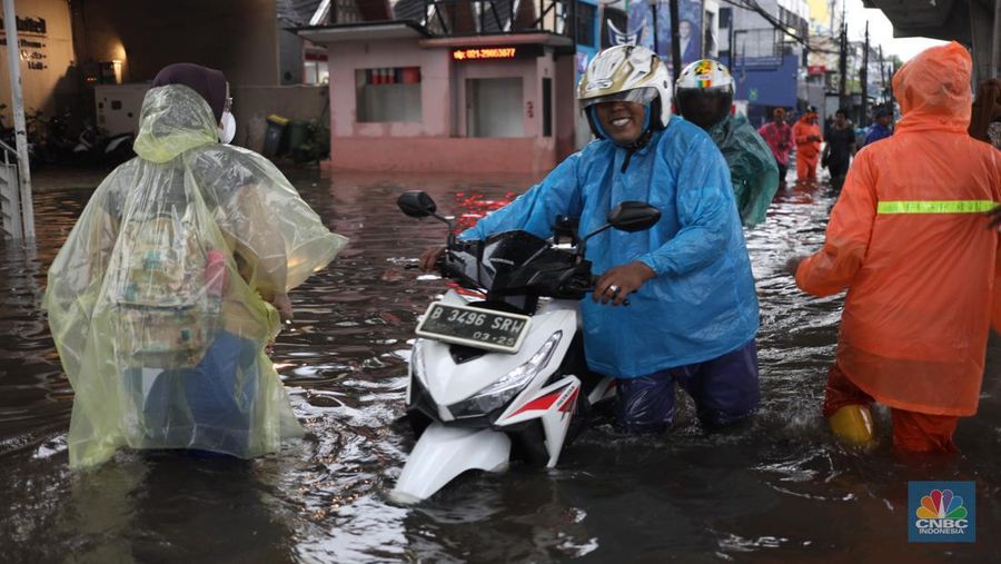 Warga menerobos banjir menggunakan sepeda motor di kawasan Seskol, Jakarta, Rabu (4/1/2023). Hujan deras mengguyur sejumlah wilayah di DKI Jakarta. (CNBC Indonesia/Tri Susilo)