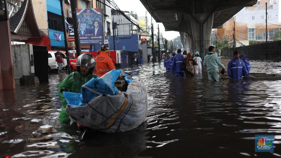 Warga menerobos banjir menggunakan sepeda motor di kawasan Seskol, Jakarta, Rabu (4/1/2023). Hujan deras mengguyur sejumlah wilayah di DKI Jakarta. (CNBC Indonesia/Tri Susilo)
