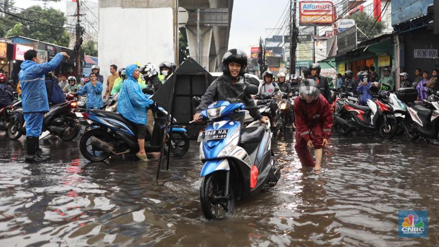 Warga menerobos banjir menggunakan sepeda motor di kawasan Seskol, Jakarta, Rabu (4/1/2023). Hujan deras mengguyur sejumlah wilayah di DKI Jakarta. (վ/Tri Susilo)