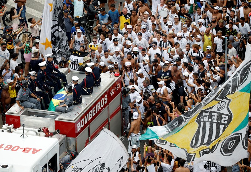 Parade Pamakaman legenda sepak bola asal Brasil Pele Sejumlah penggemar berkumpul saat mobil pemadam kebakaran yang membawa jenazah legenda sepak bola asal Brasil Pele melintas dari Stadion Vila Belmiro Santos untuk melakukan prosesi pemakaman di Santos, Brasil, Selasa (3/1/2022). Legenda sepak bola asal Brasil Pele meninggal dunia di usia 82 setelah berjuang melawan penyakit kanker usus besar, Kamis (29/12/2022) waktu setempat. (REUTERS/Amanda Perobelli)
